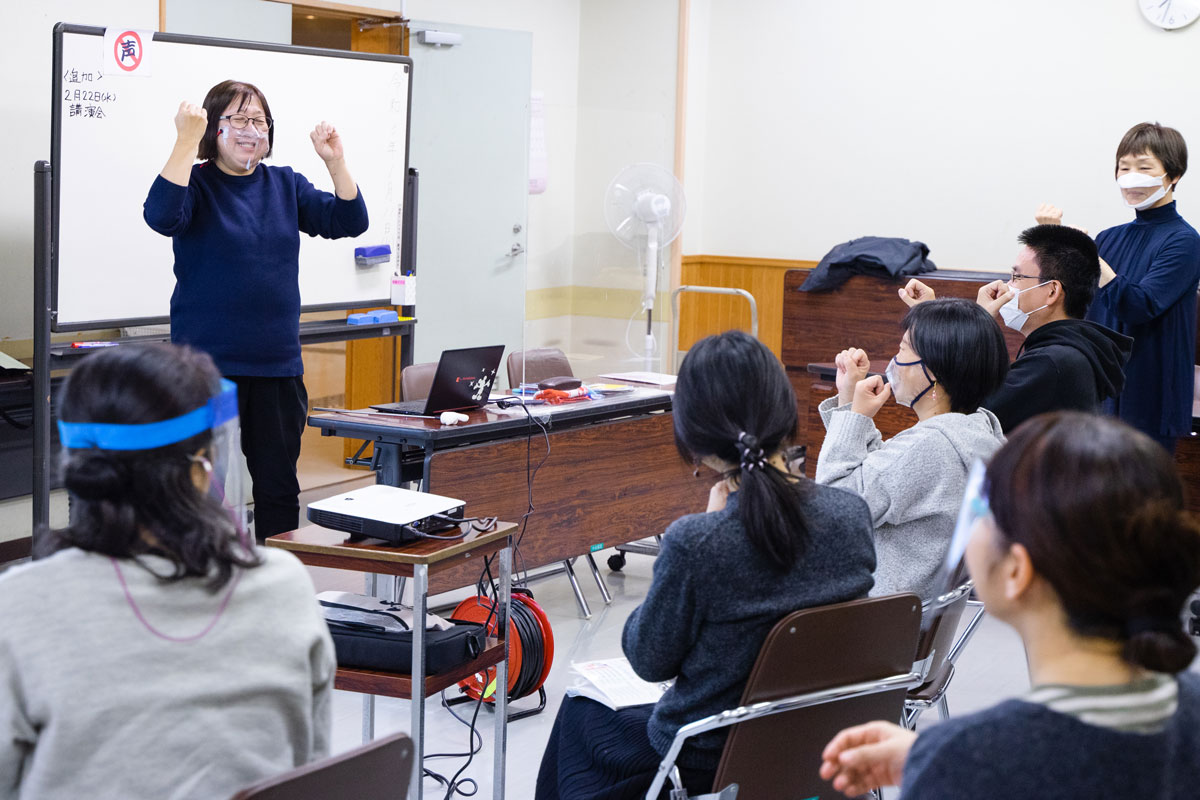 手話講習会の様子。実際に手話の動きをやってみている。