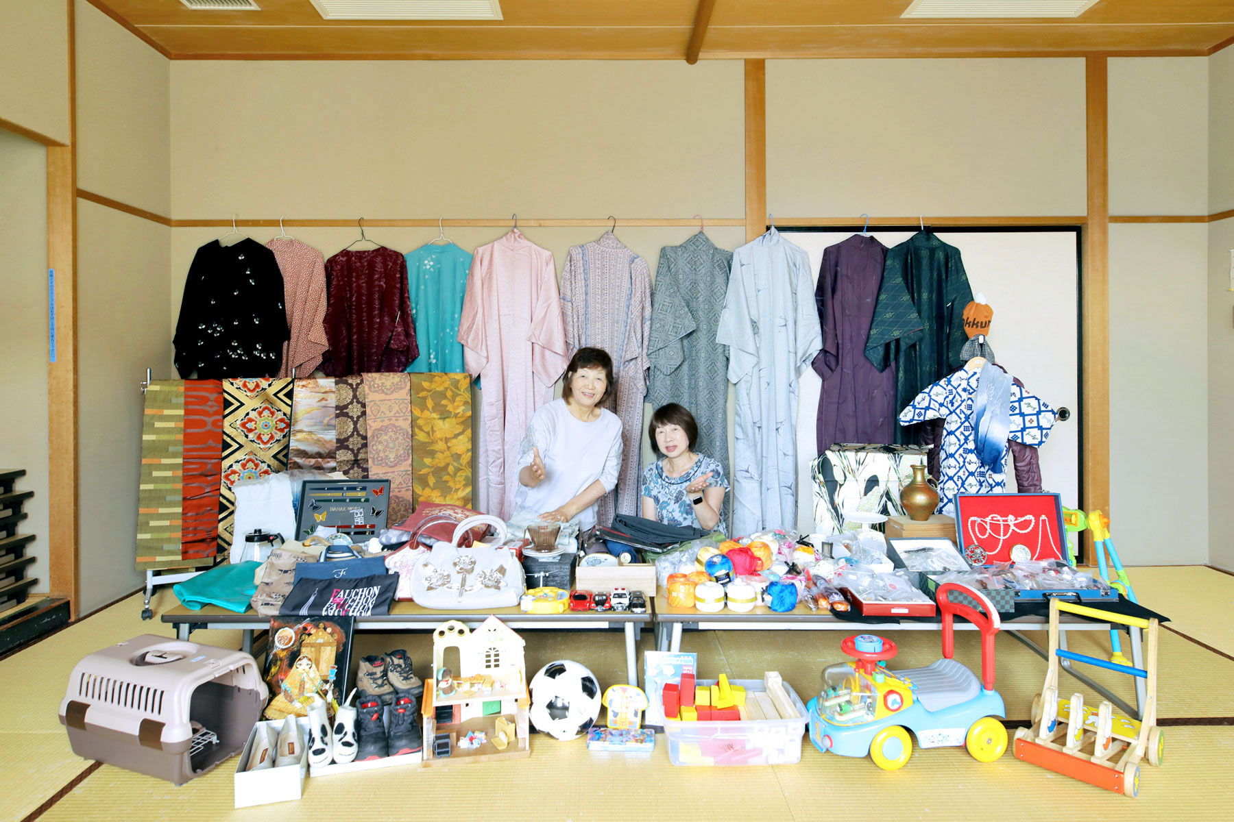 広めの和室に色とりどりの着物と雑貨、子ども用品が並んでいる。そのブースの中央に二人の女性がポーズをとって写っている。