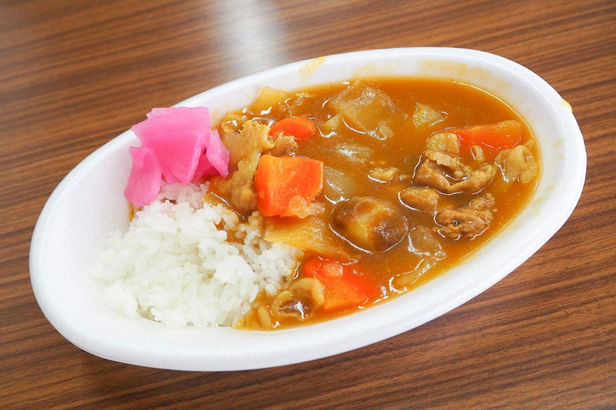 カレーの写真。ごろっとした人参とお肉、玉ねぎ、お芋。福神漬けもついている。